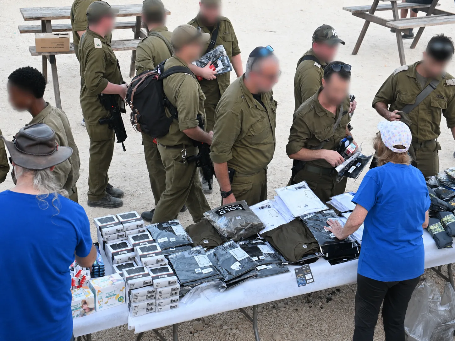 Volunteers handing out fresh clothing and supplies to soldiers at a field table