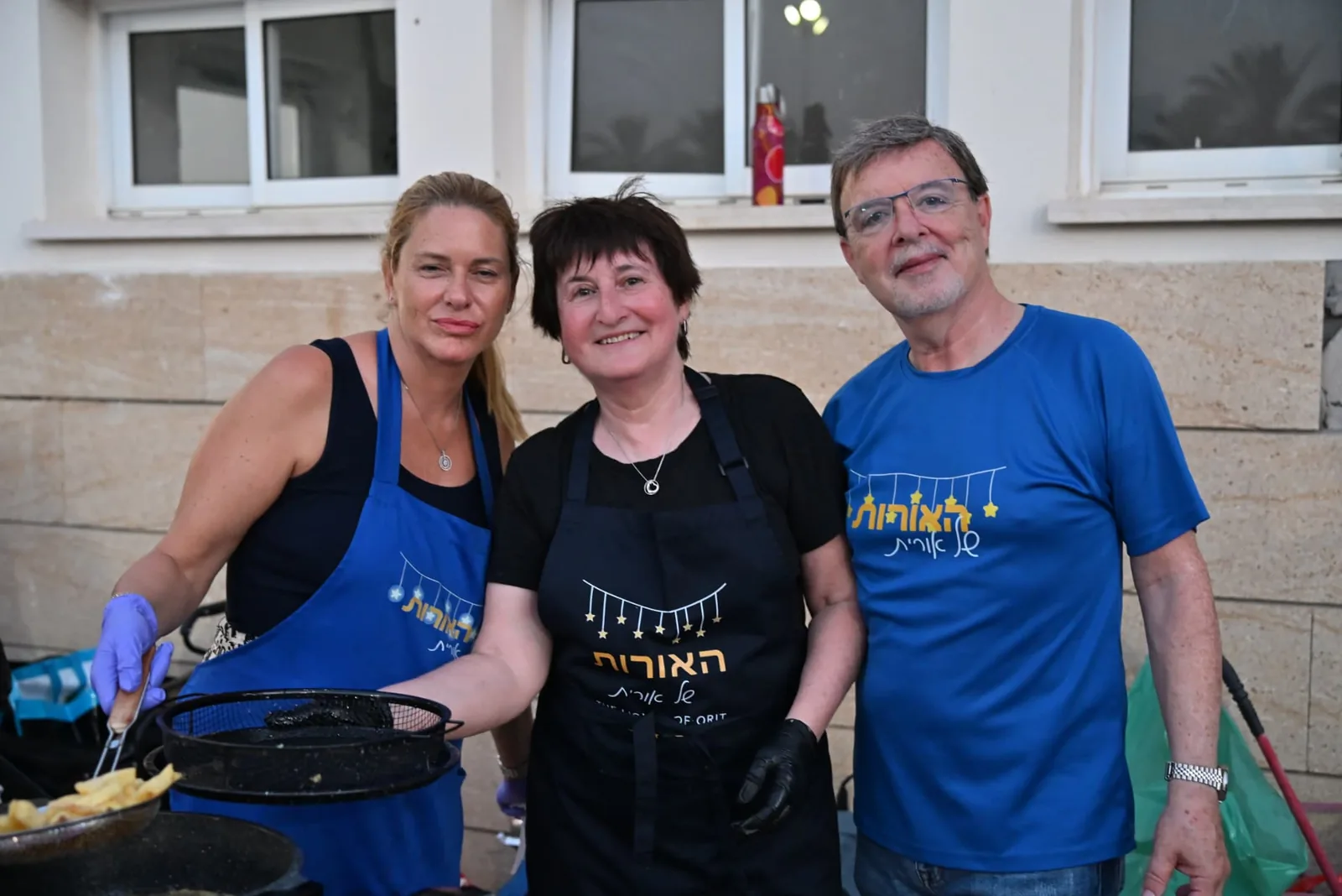 Three volunteers at the frying station