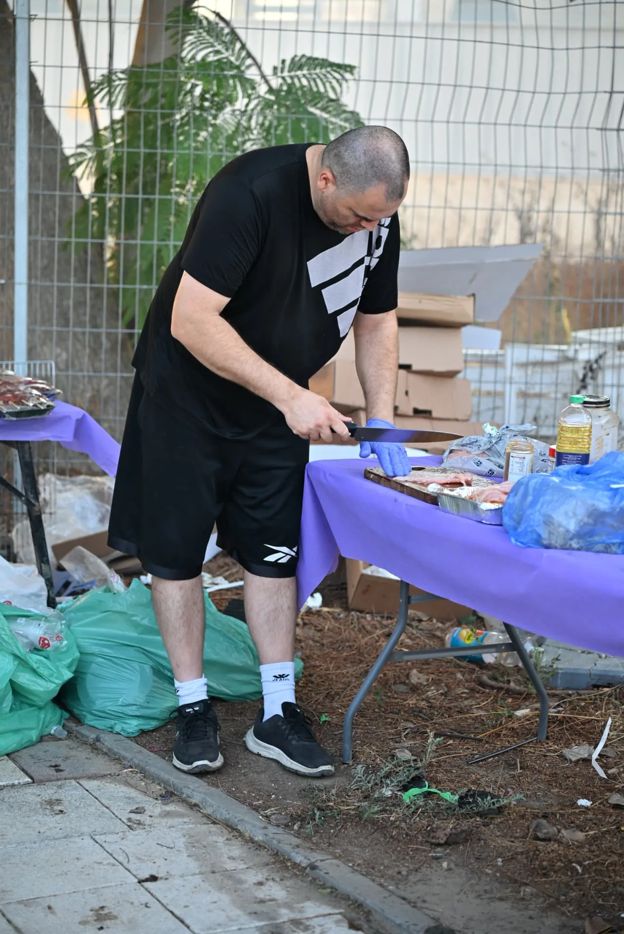 A volunteer preparing meat at a field prep table