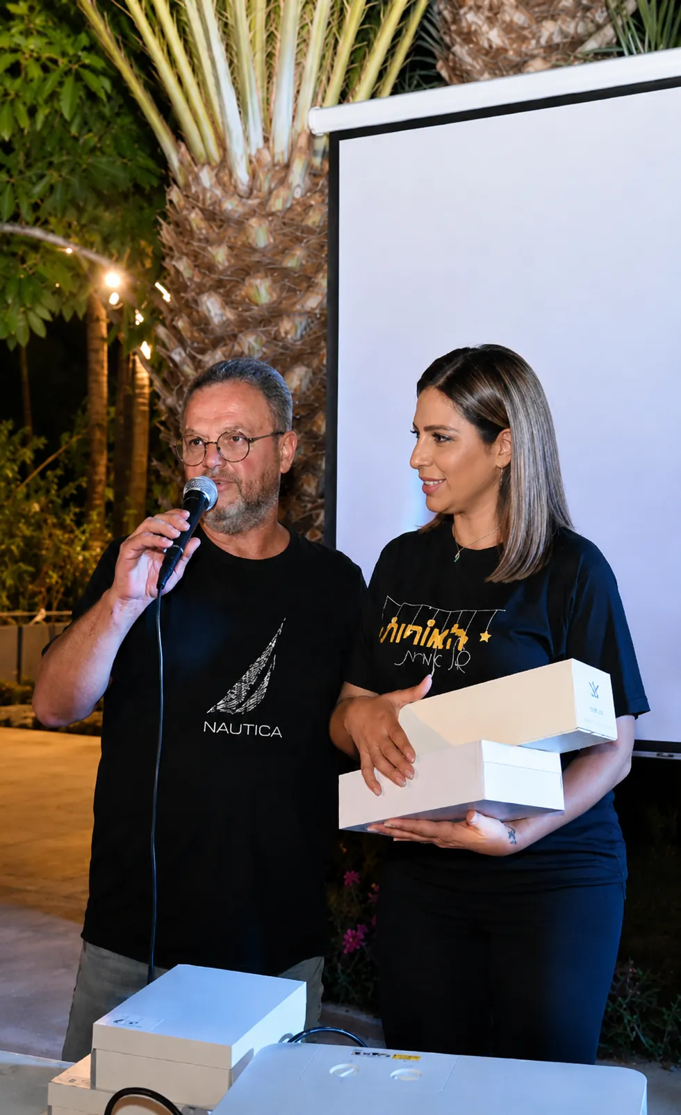 Orit Cohen Peleg and a colleague on stage at a community event