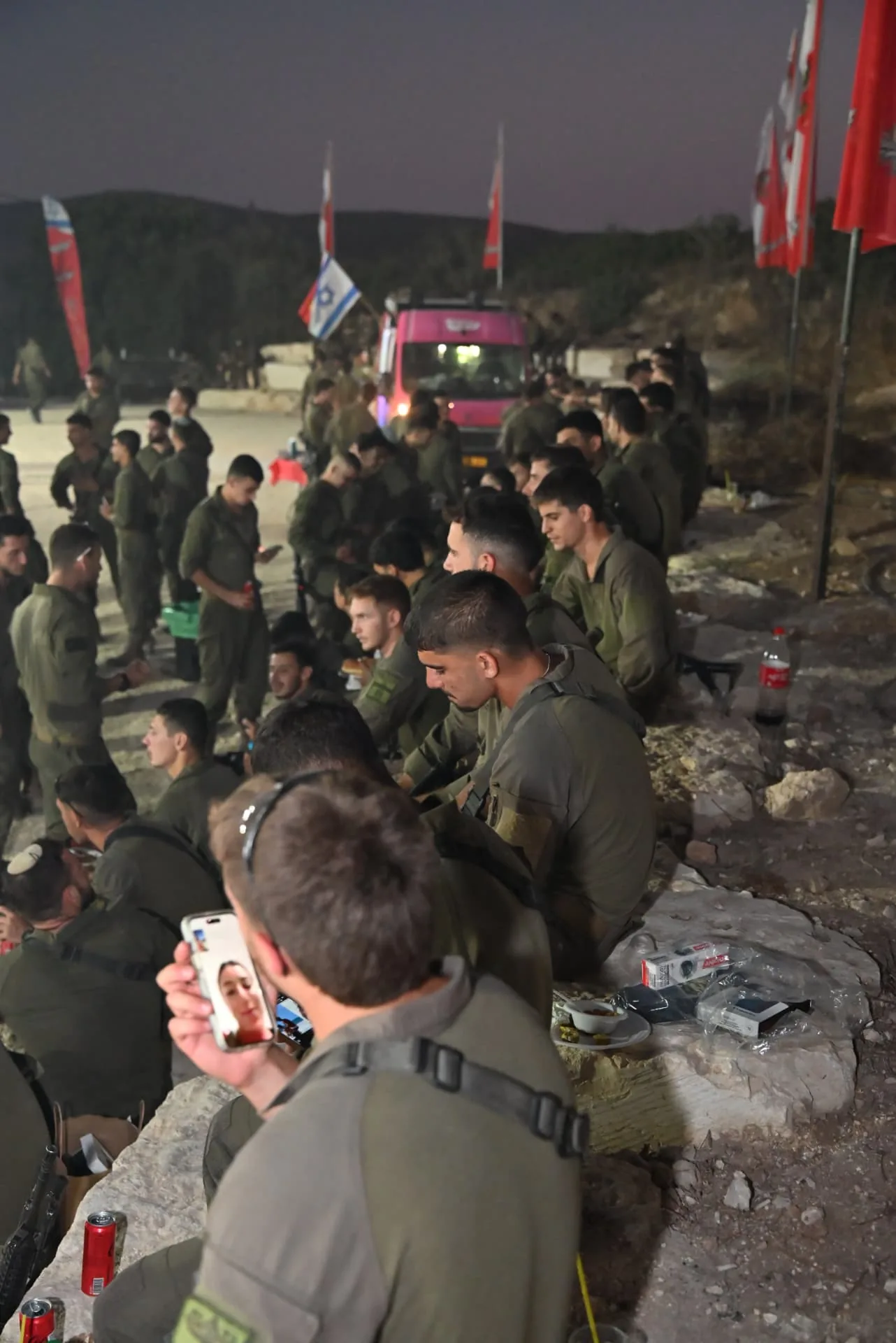 Soldiers resting and eating as night falls