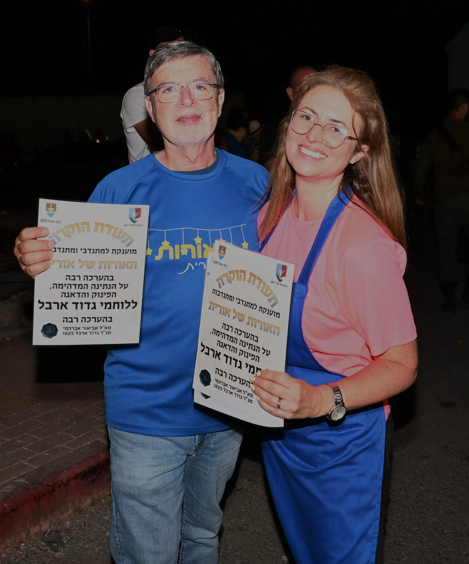 Recognition moment with volunteers holding appreciation certificates at the Arbel event