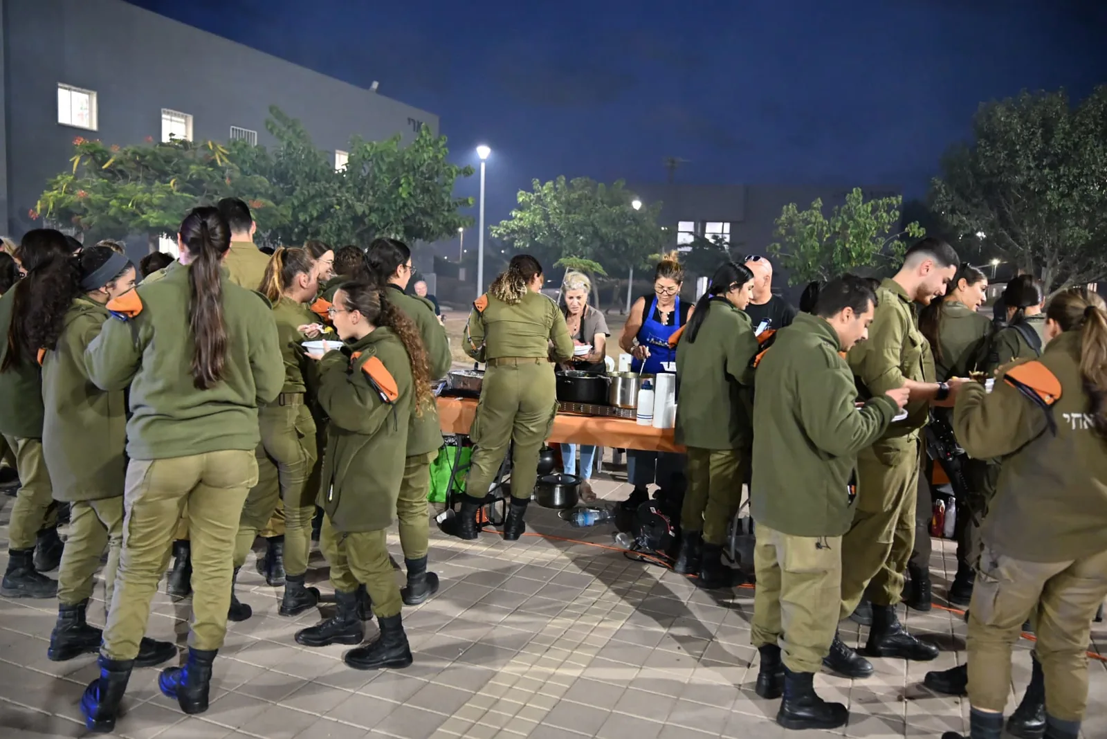 Soldiers gathered at the buffet as volunteers serve food at the appreciation evening