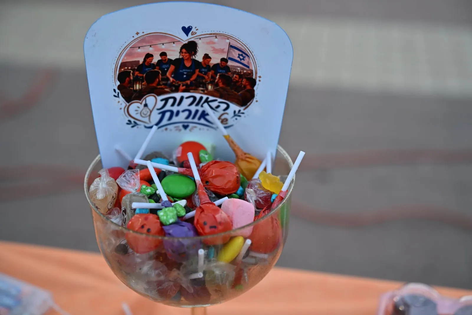 A decorated cup of sweets with The Lights of Orit branding