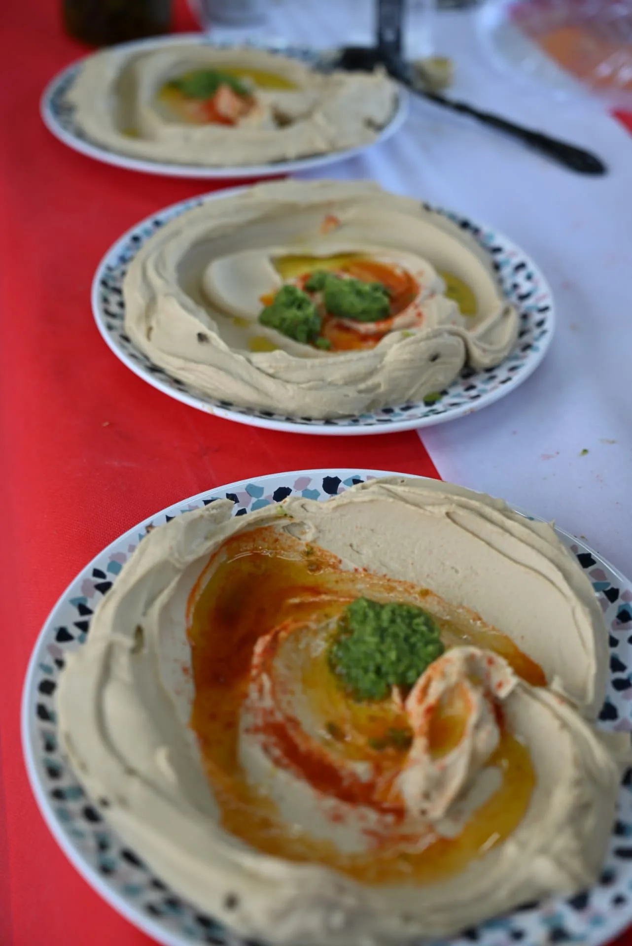 Plates of freshly made hummus with olive oil and herbs
