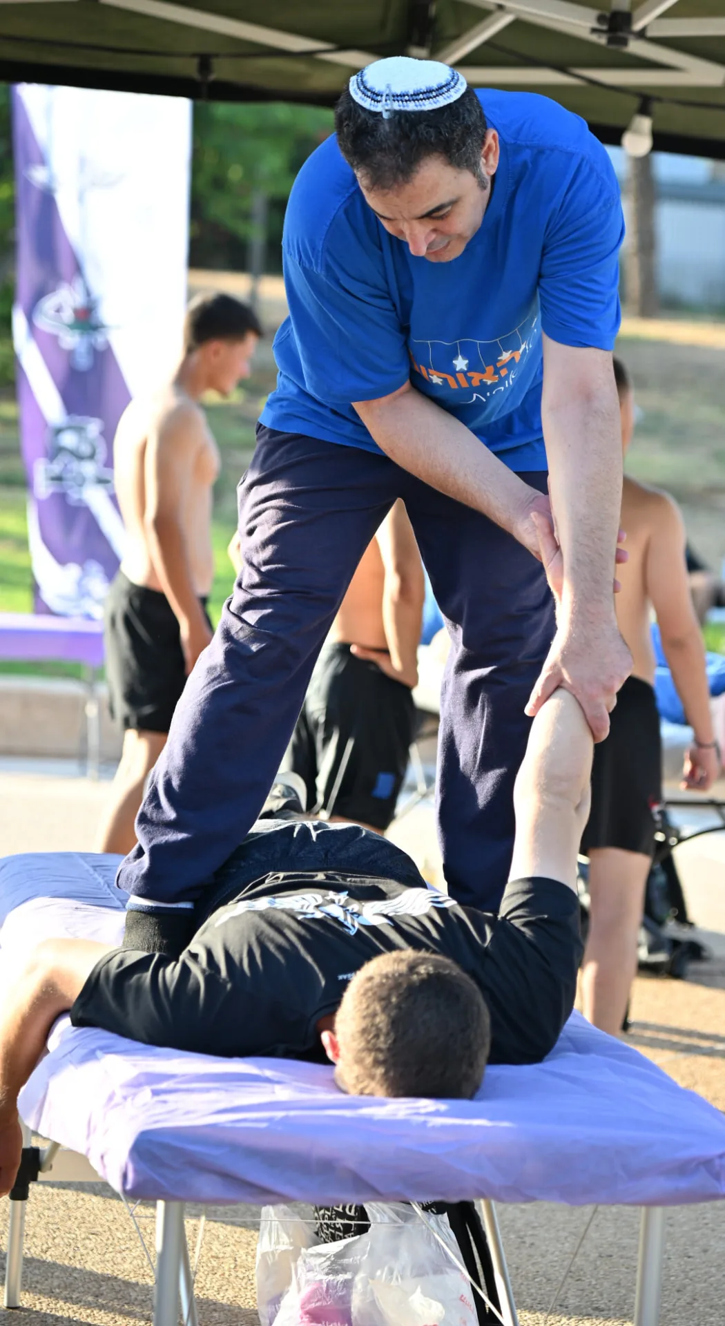 Volunteer therapist stretching a soldier's legs