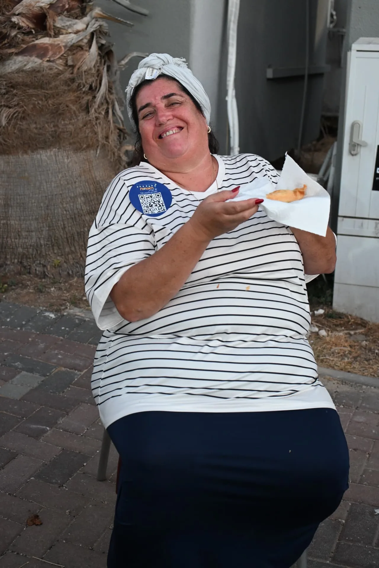 A smiling volunteer taking a break with a fresh doughnut
