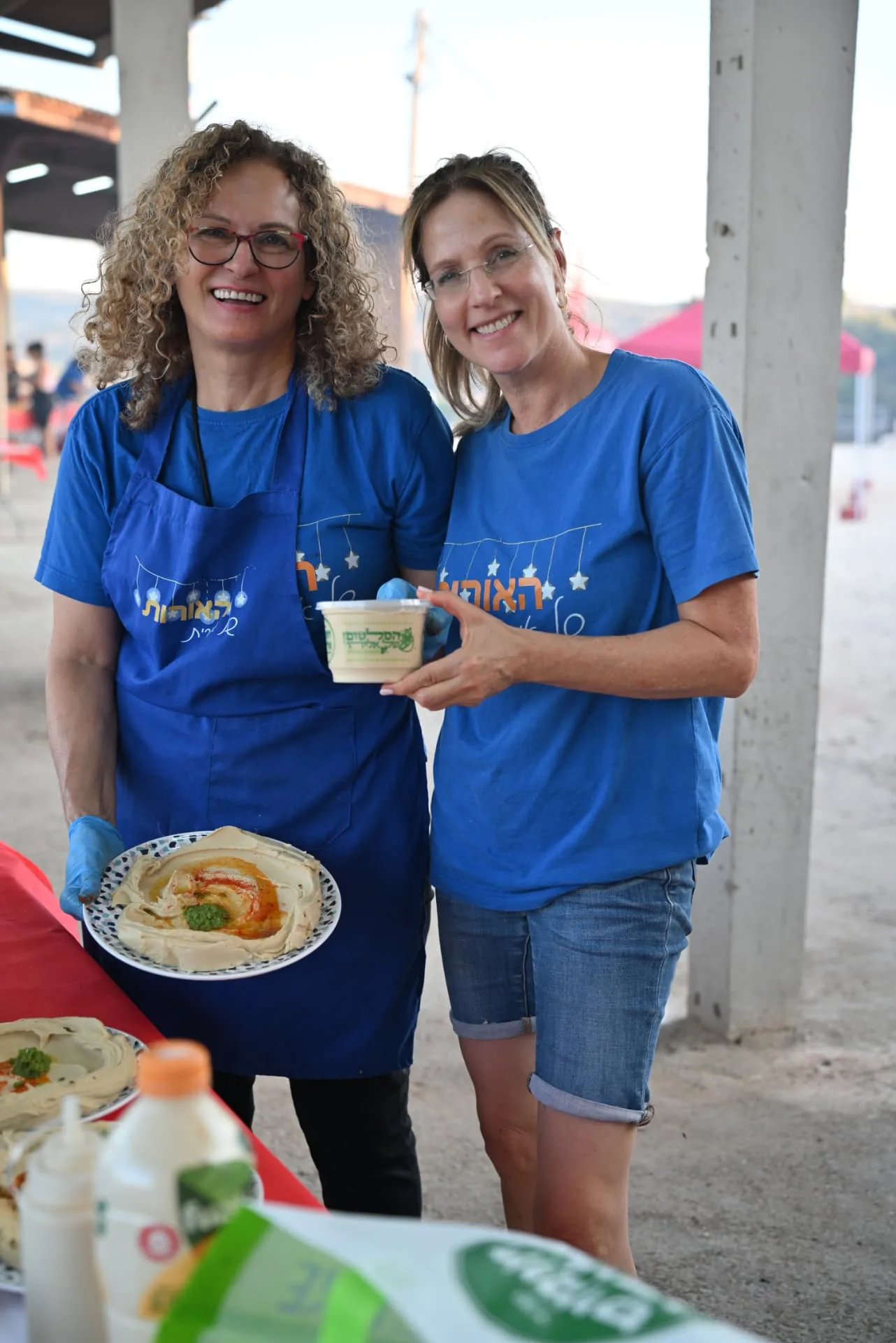 Volunteers holding plates of freshly made hummus