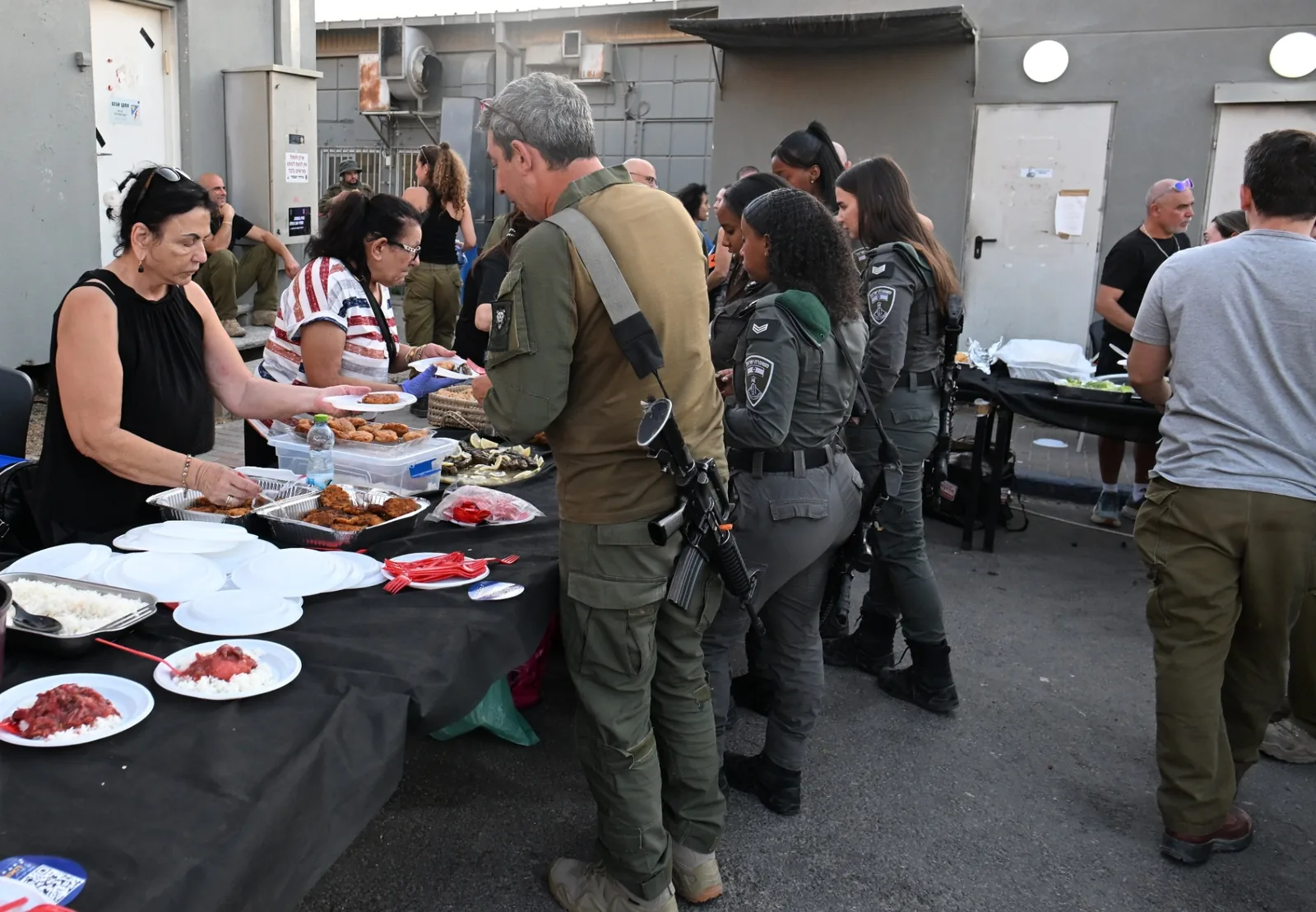 A volunteer handing a full plate across the serving table