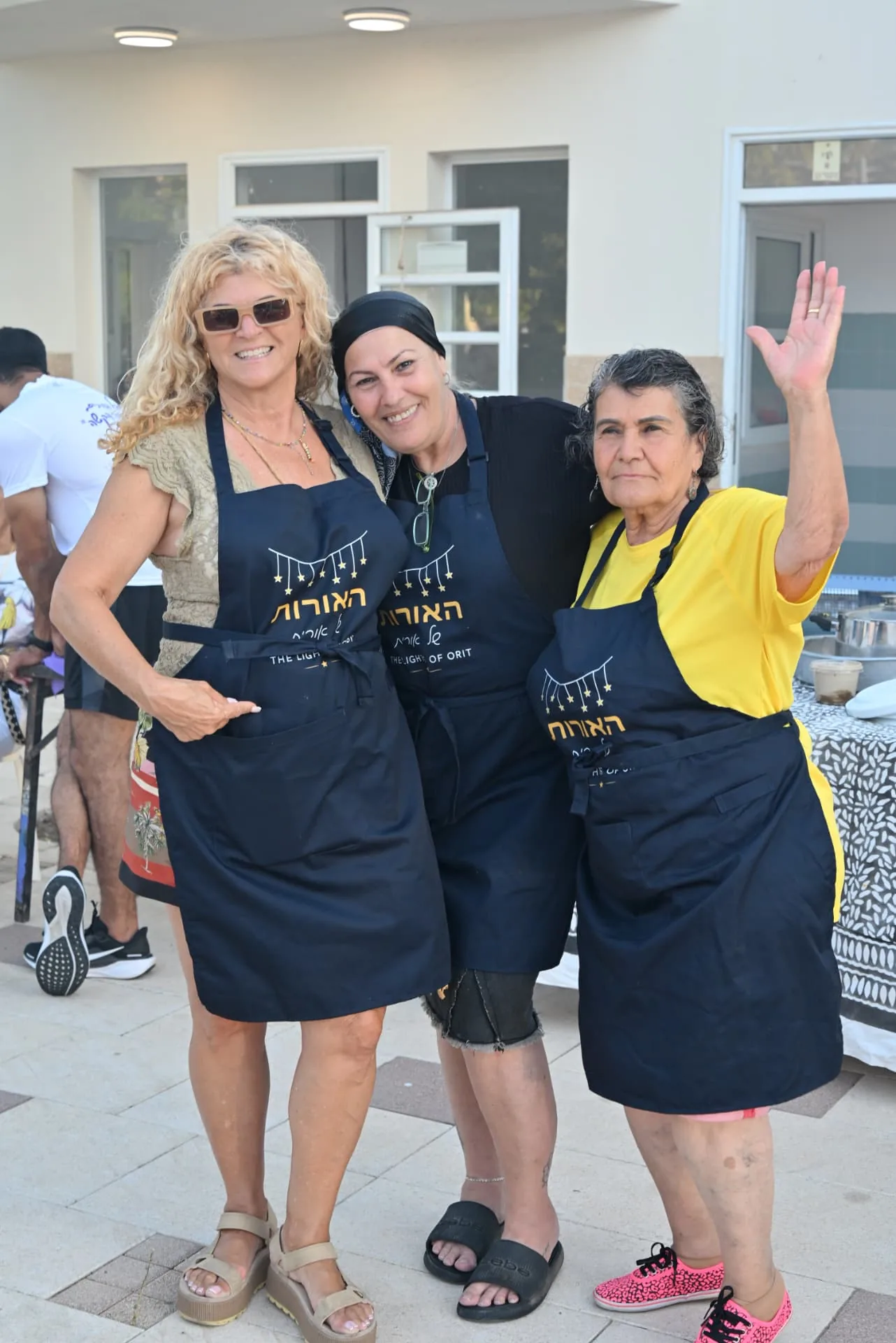 Three volunteers in Lights of Orit aprons