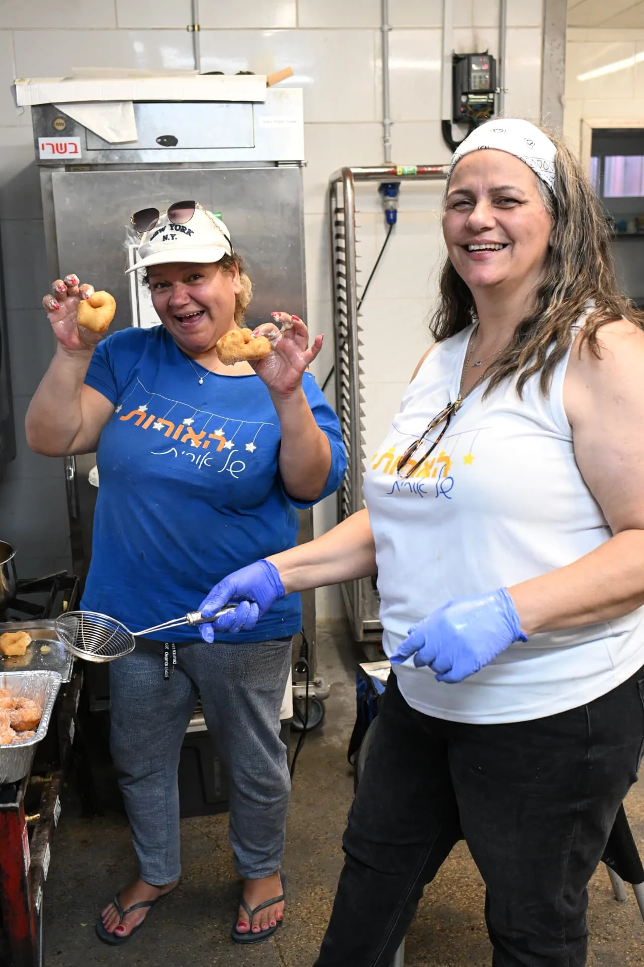Two volunteers frying fresh doughnuts in the field kitchen