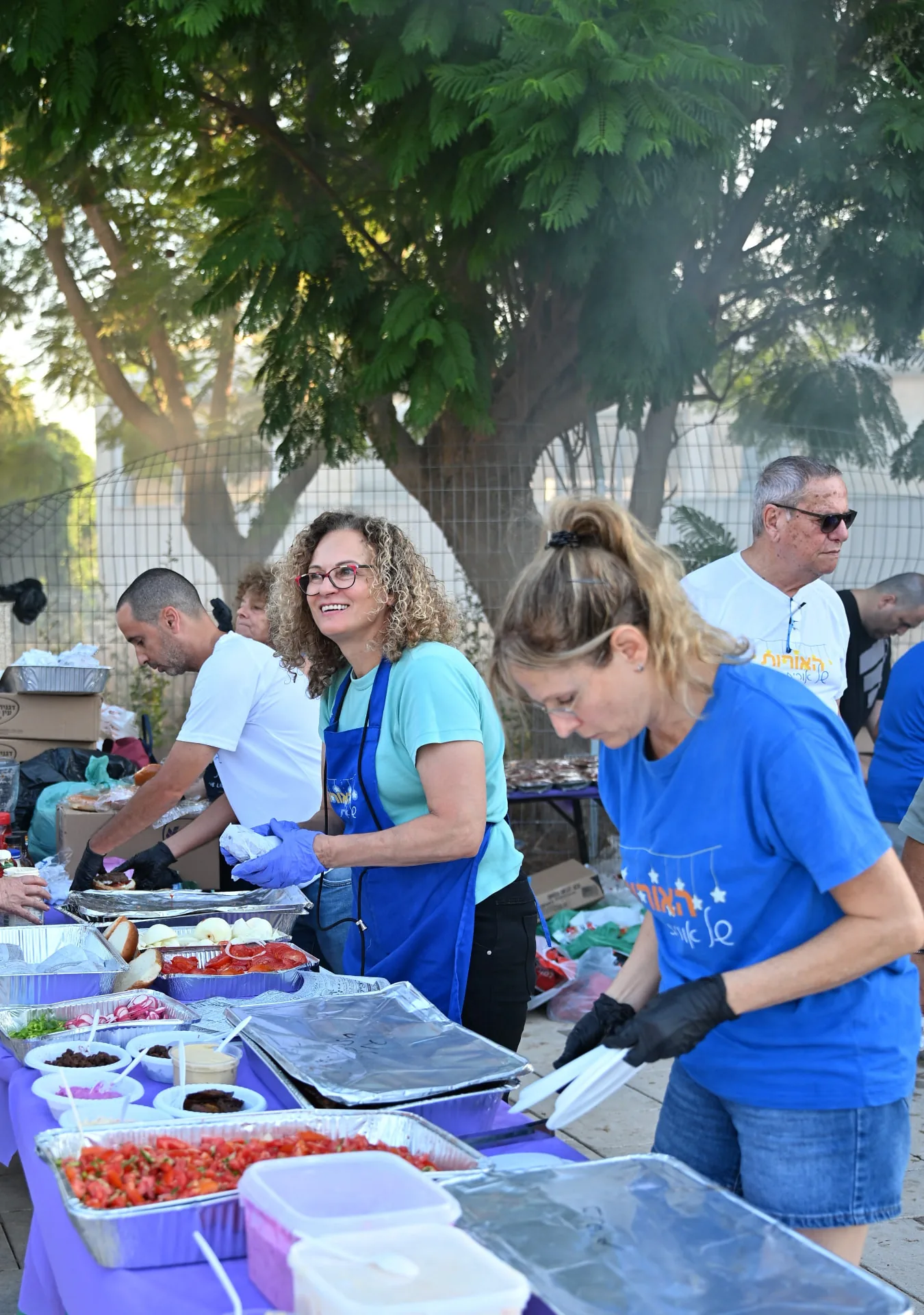Volunteers assembling burgers along a serving line