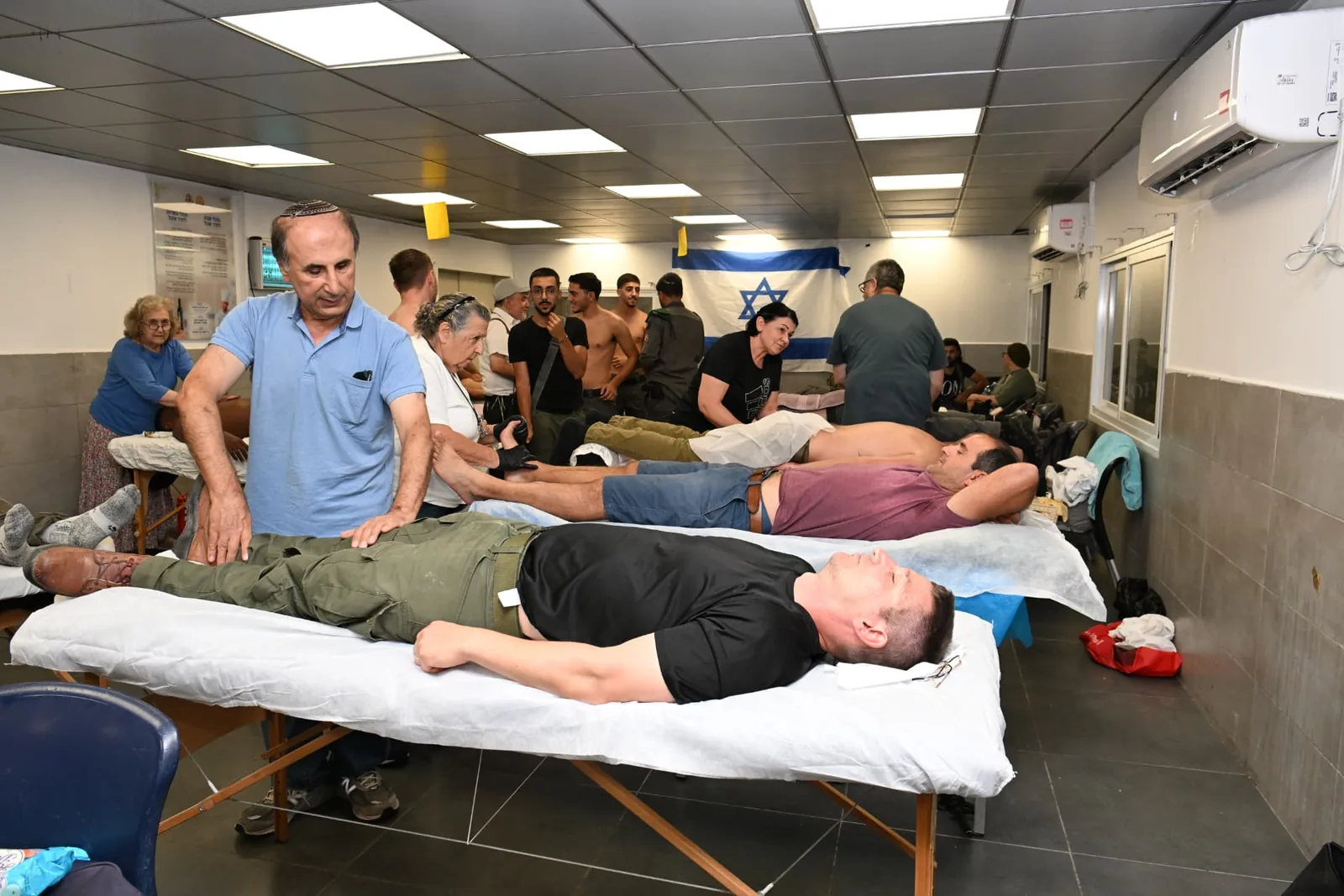 Volunteer therapists treating soldiers in a busy clinic room
