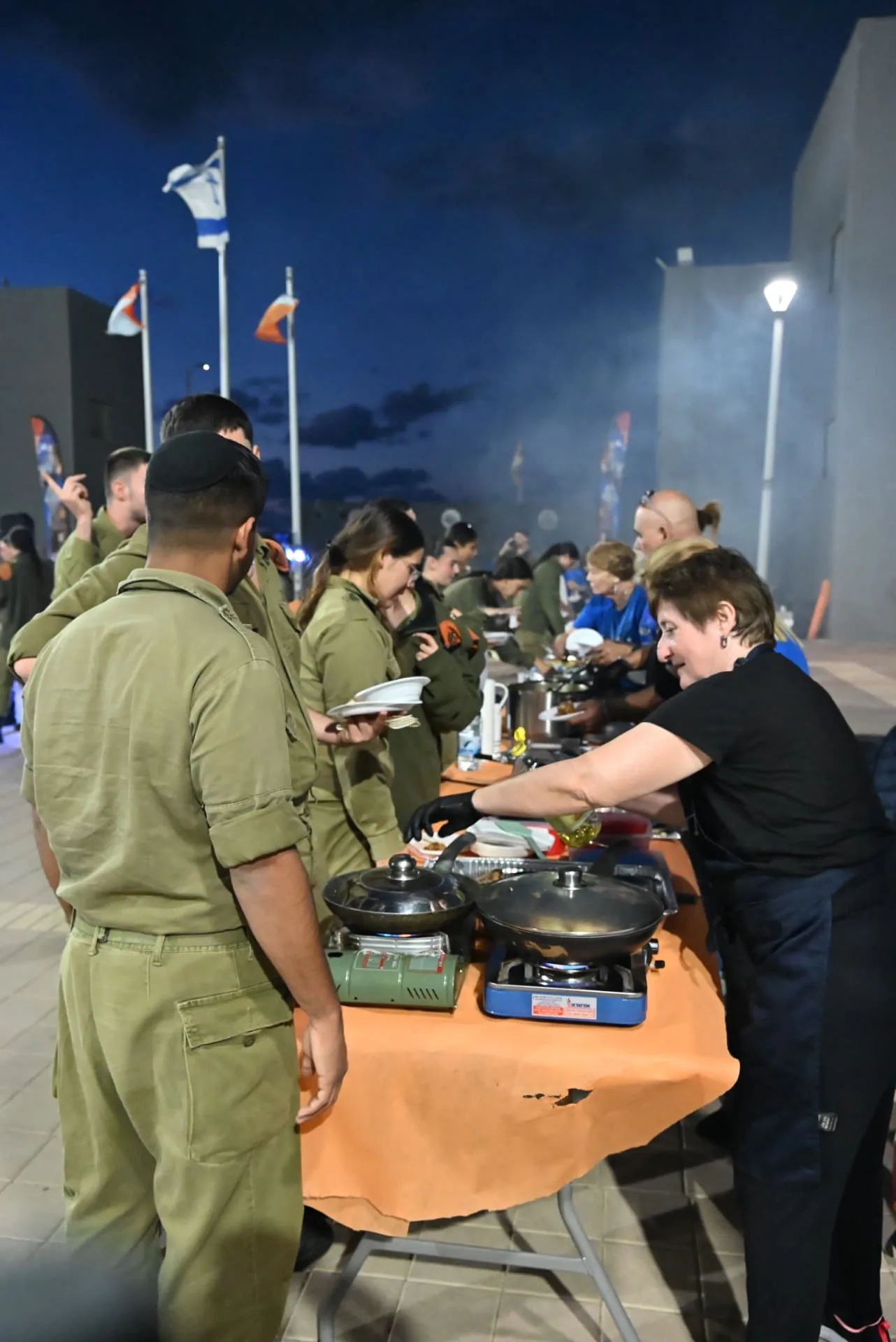 A volunteer serving soldiers at the buffet