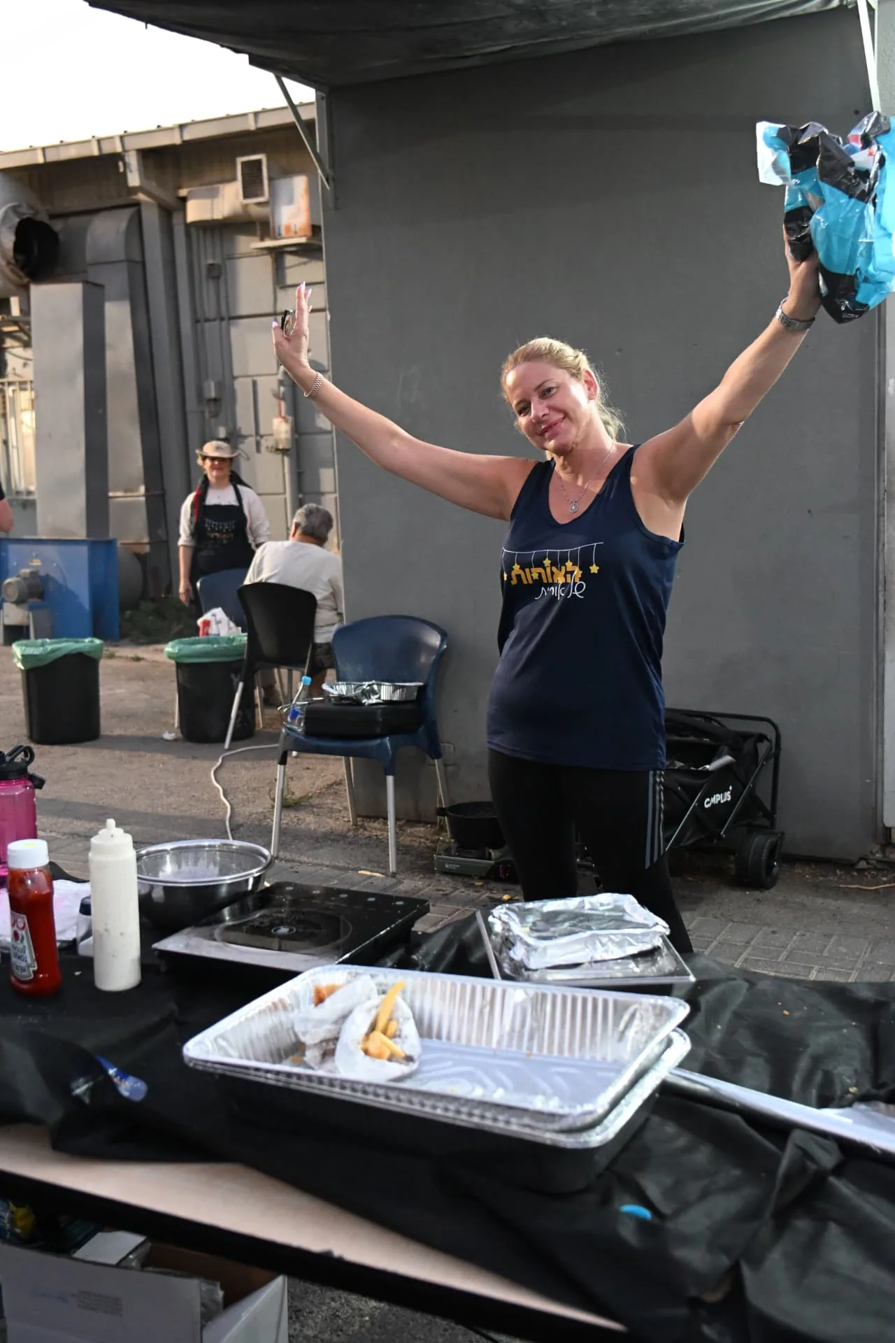 A volunteer raising her arms in celebration behind the food station