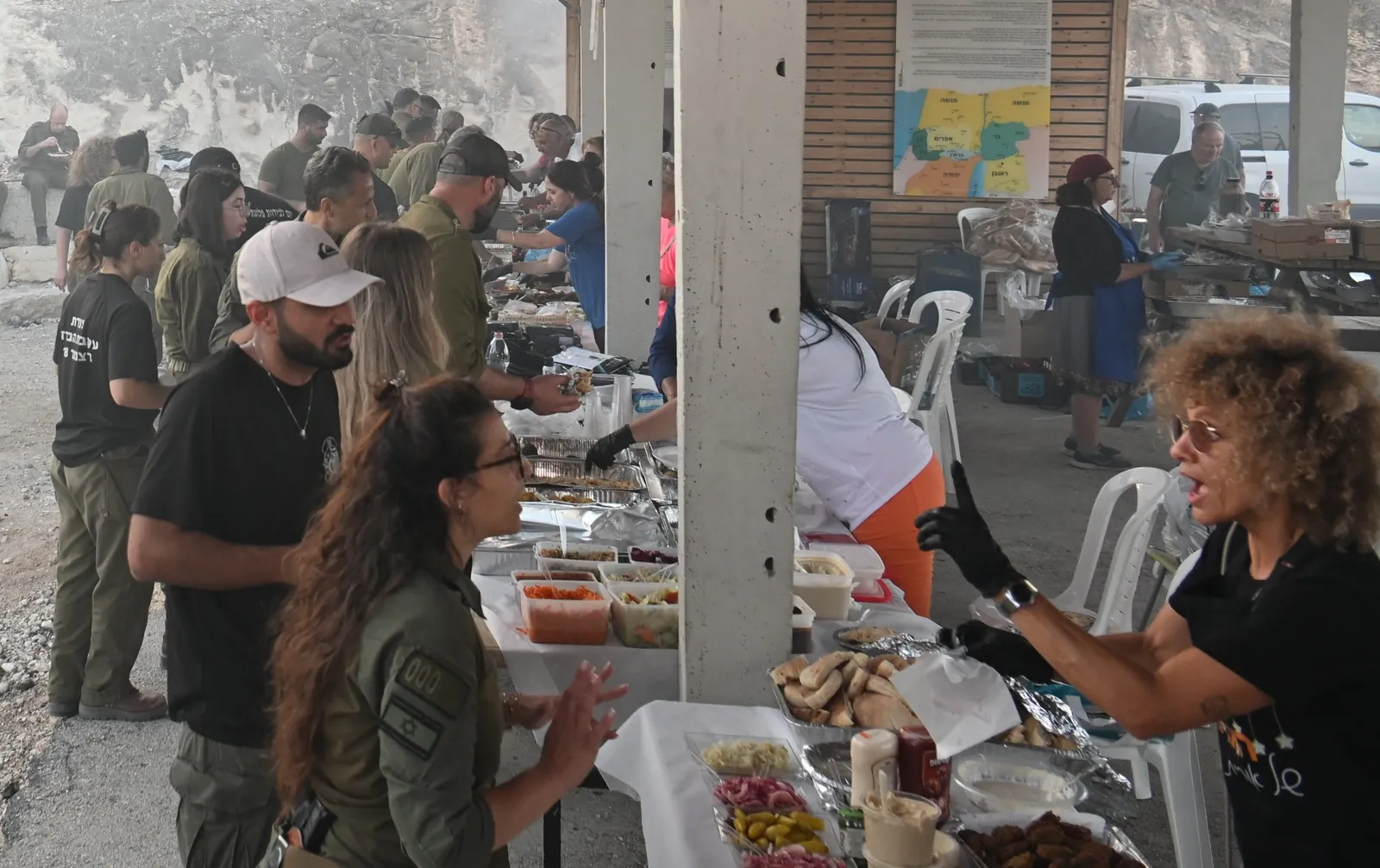 Soldiers and volunteers at the food stations under the shelter