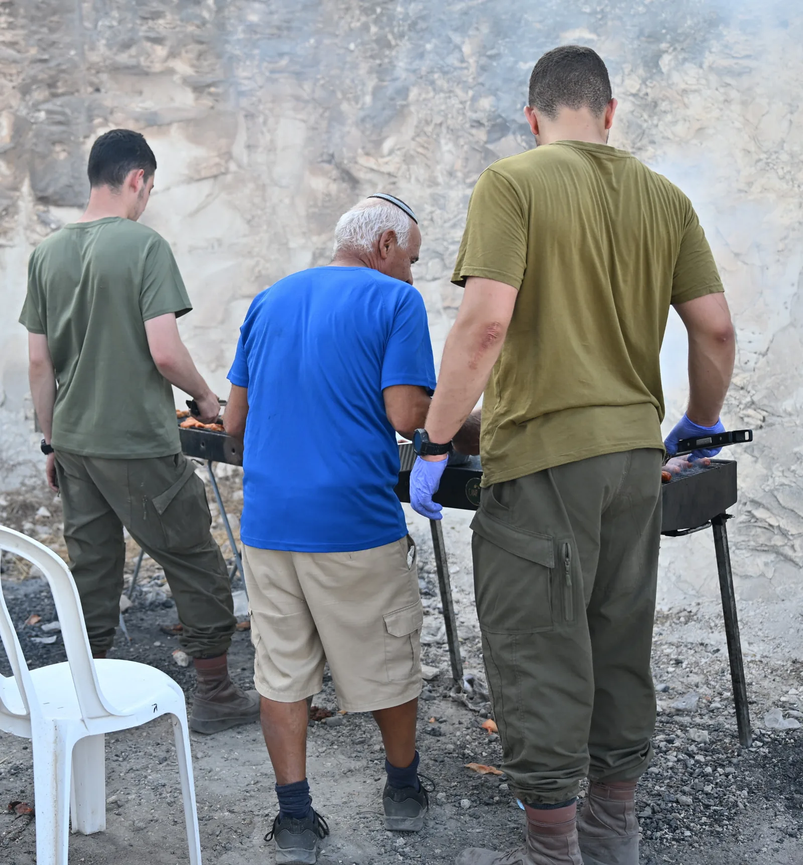 Volunteers and soldiers working the grills together