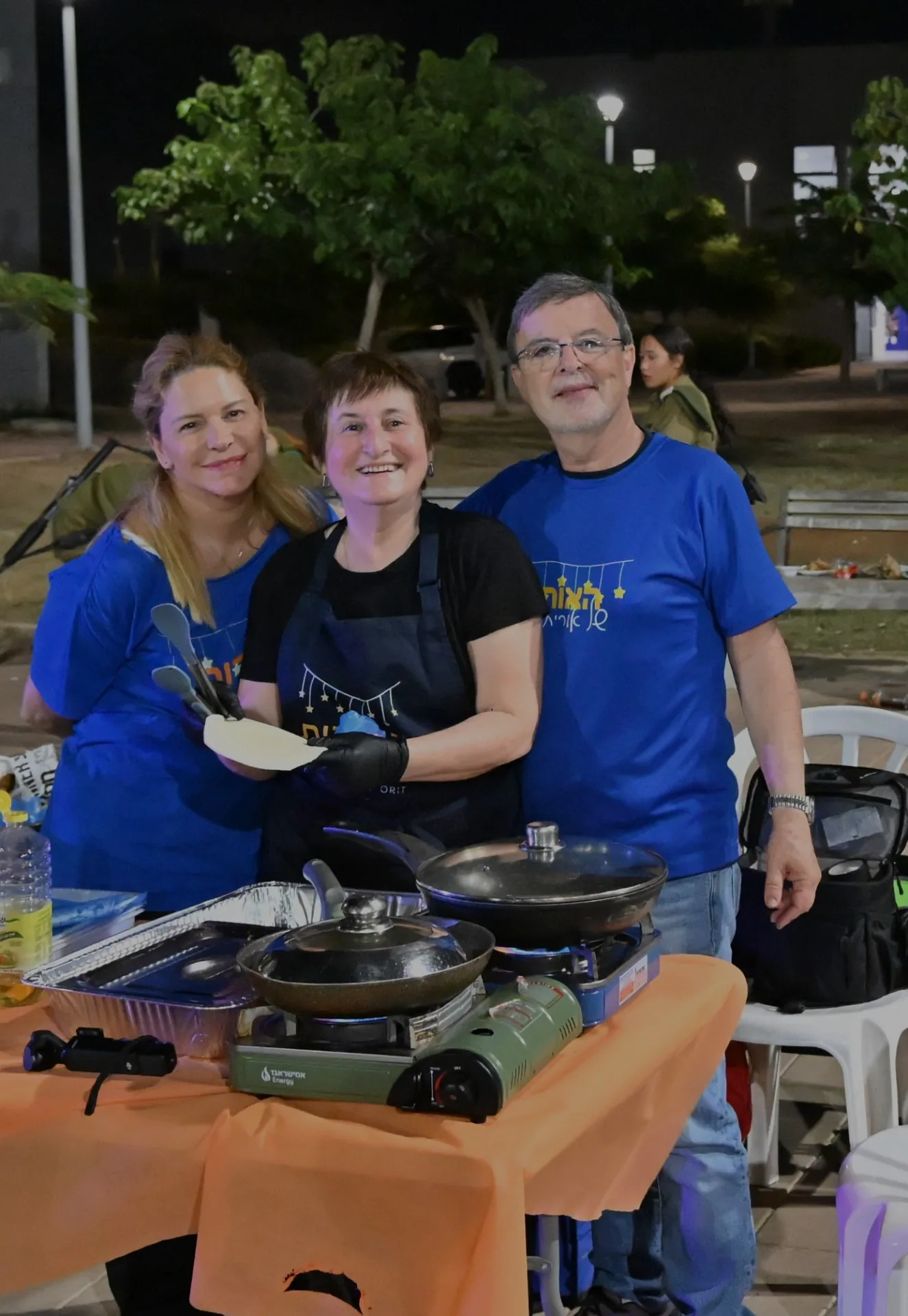 Three volunteers together behind the serving table
