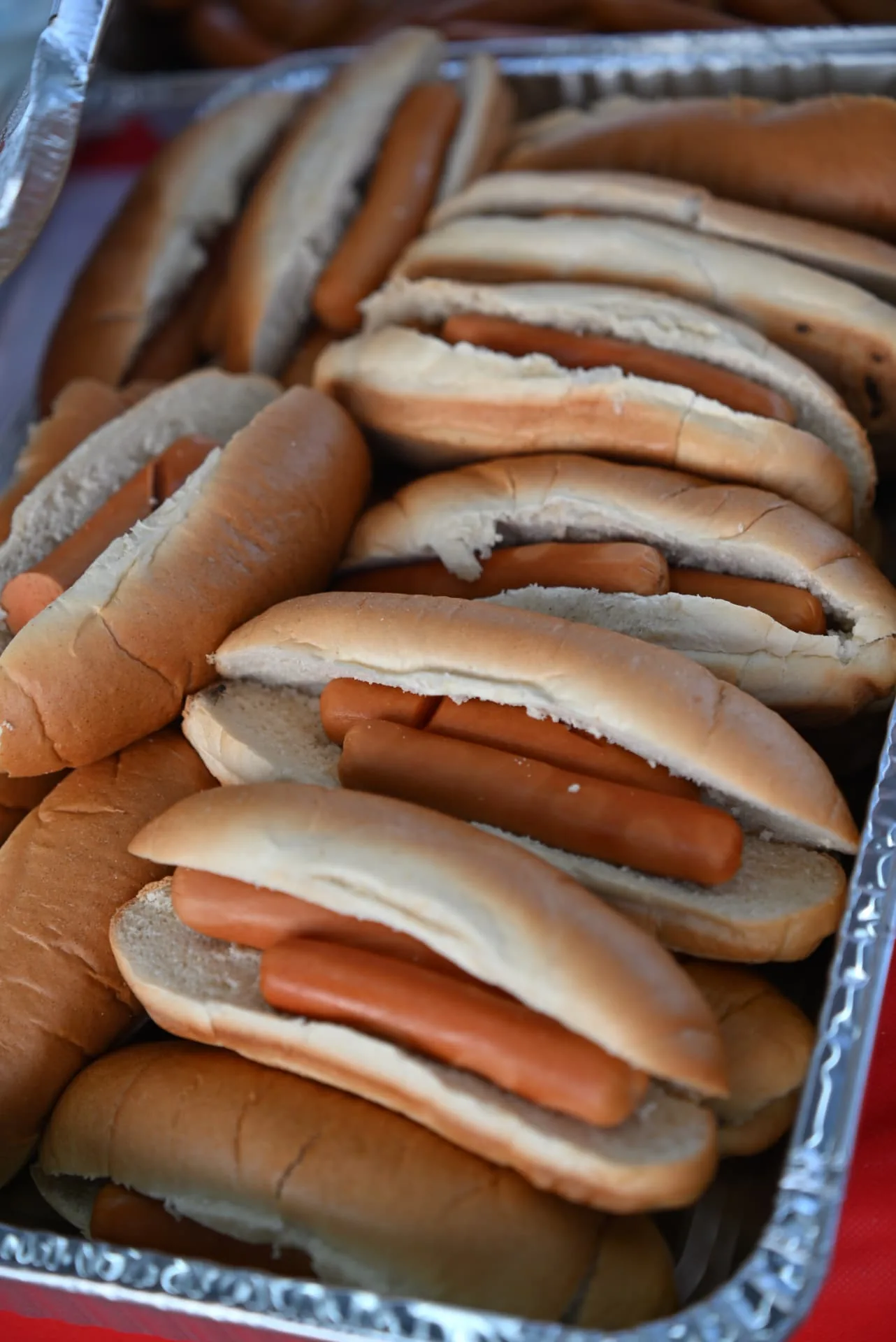A tray of hot dogs in buns ready for the soldiers