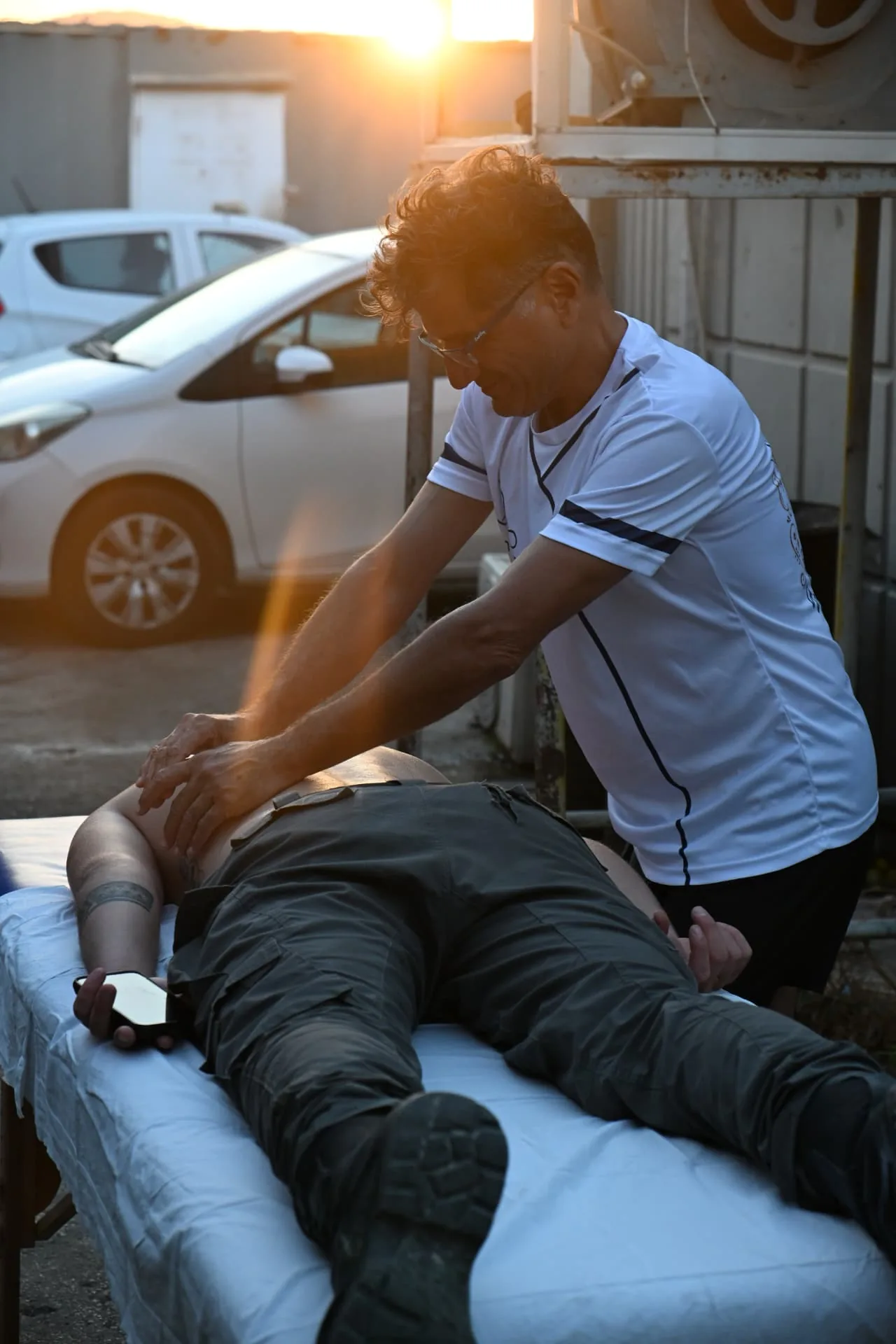 A volunteer therapist treating a soldier at sunset