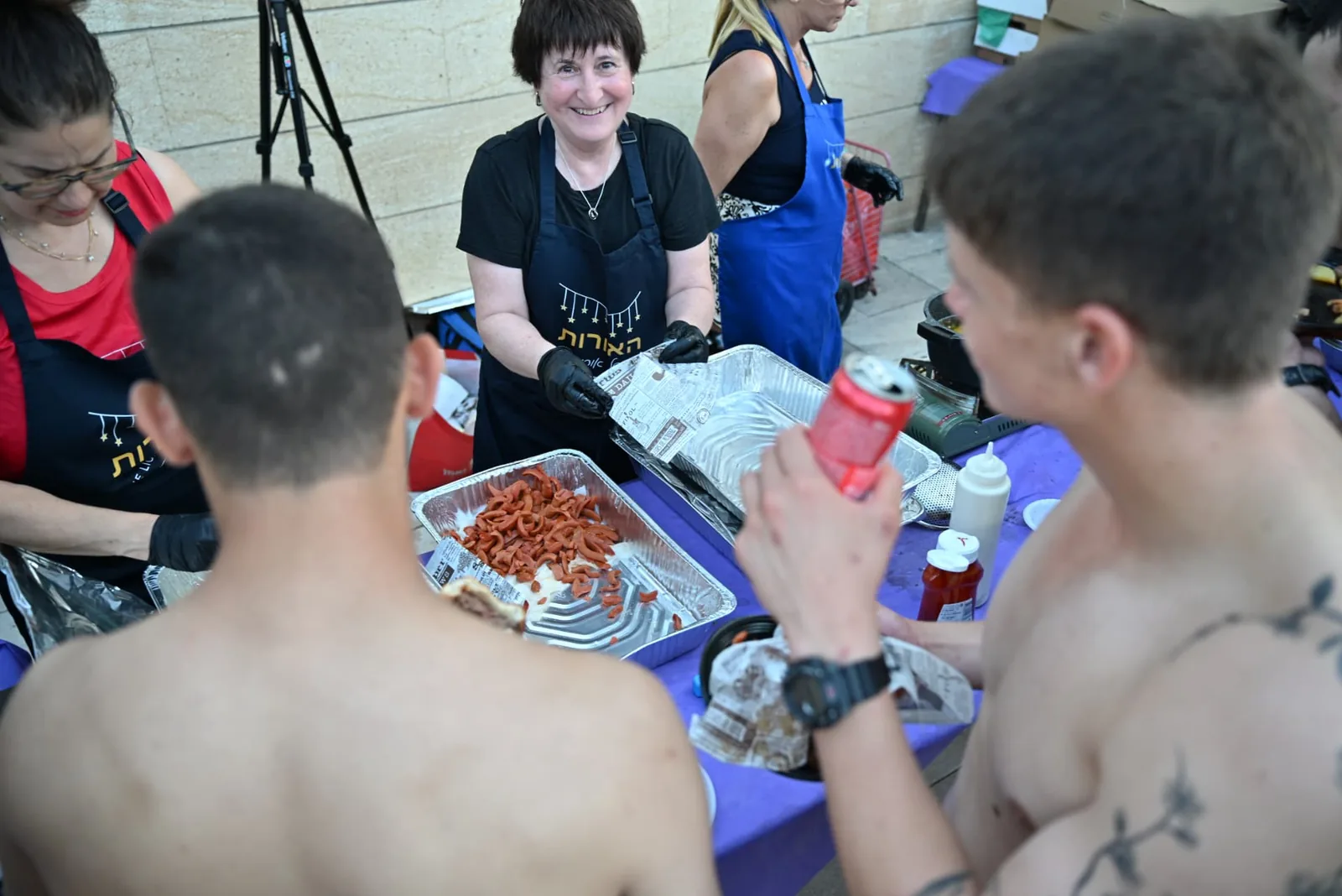 Volunteer serving soldiers across the food table