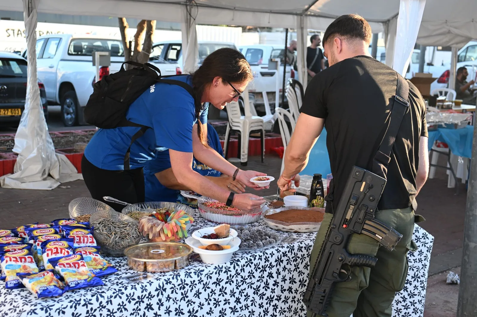 A soldier being served homemade desserts at the appreciation table