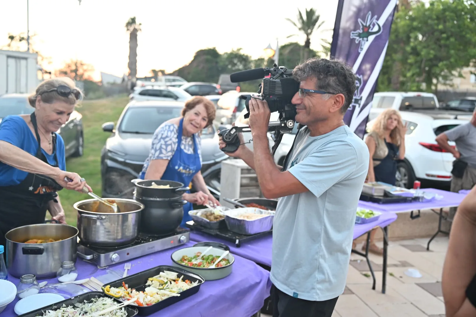 Volunteers plating hot food as cameras roll