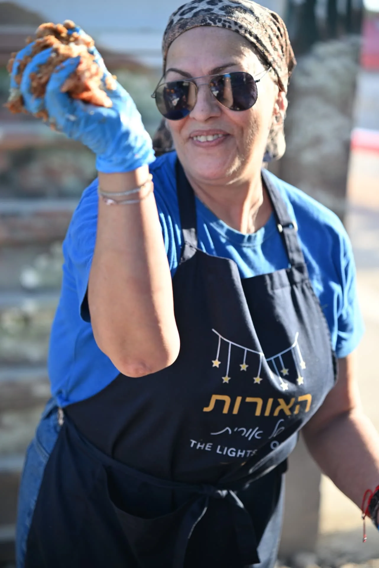 A volunteer shaping patties with a smile
