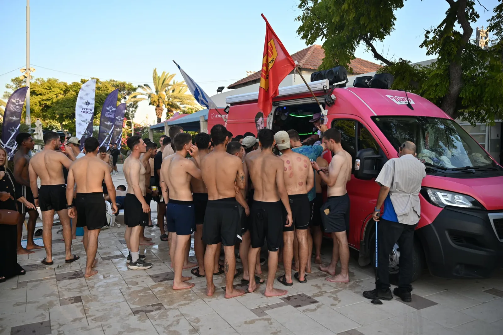 Soldiers gathered around a mobile treatment van under brigade flags