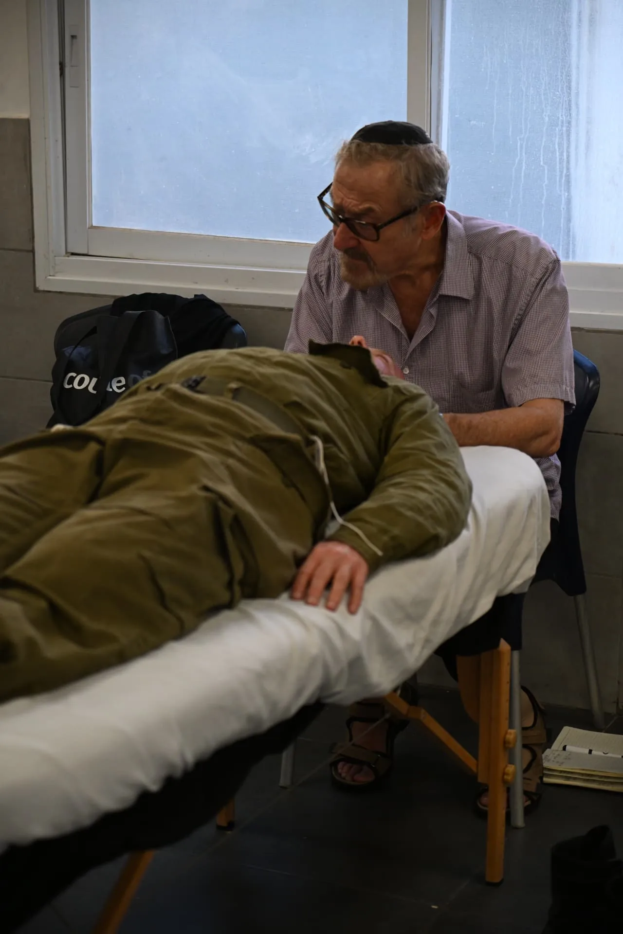 A volunteer therapist working with a resting soldier