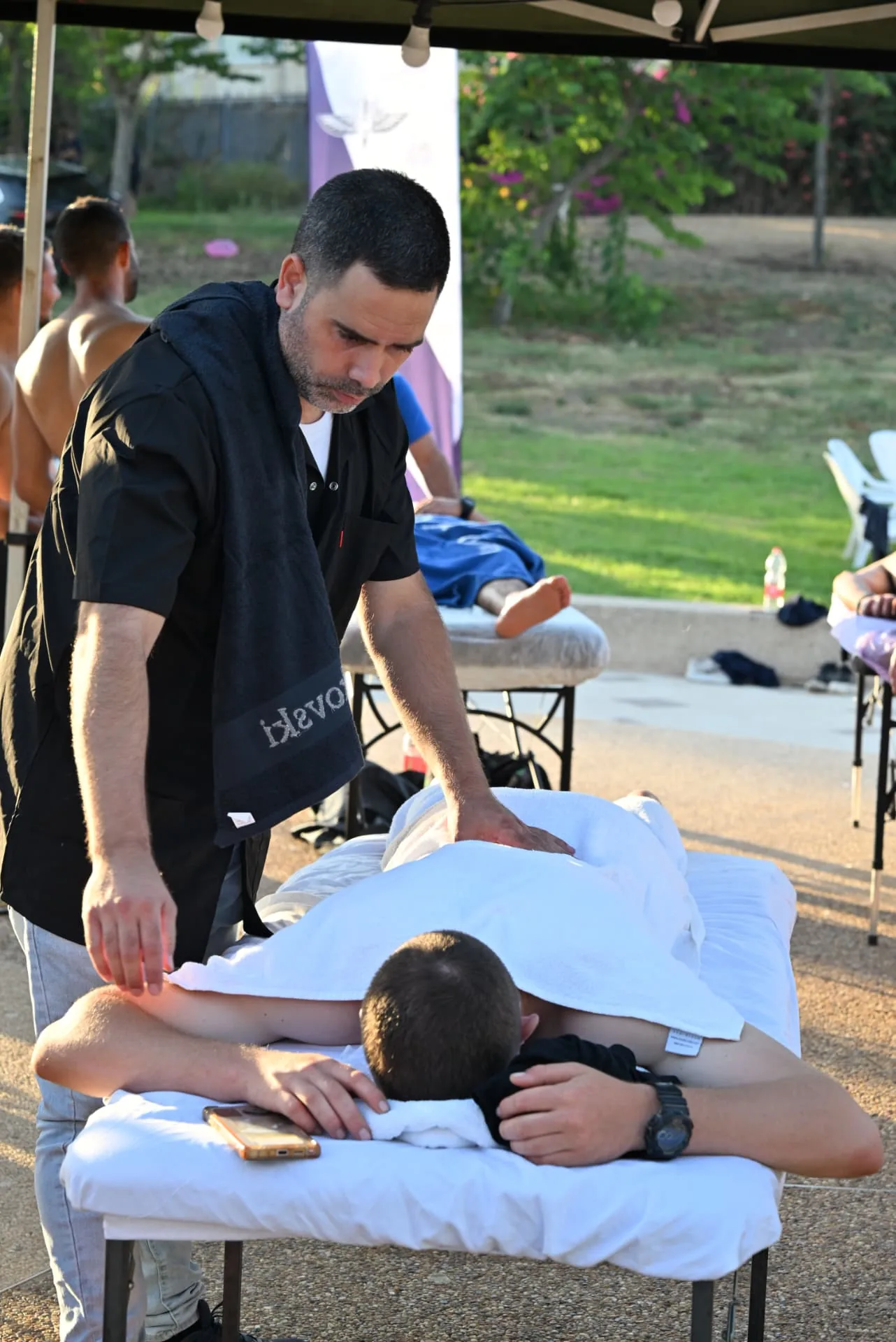 Massage therapist treating a soldier under the canopy