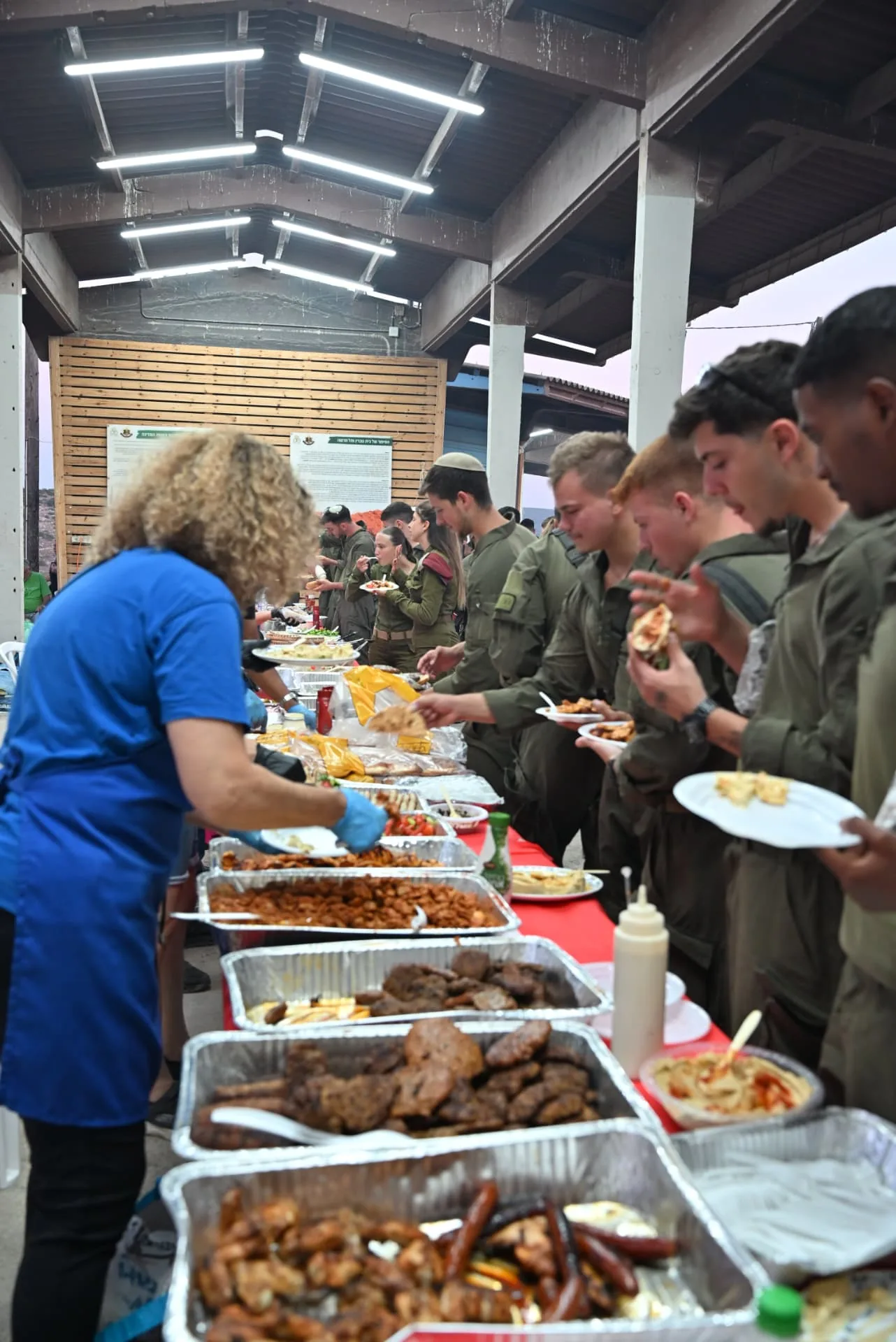 A volunteer serving hot food to the soldiers