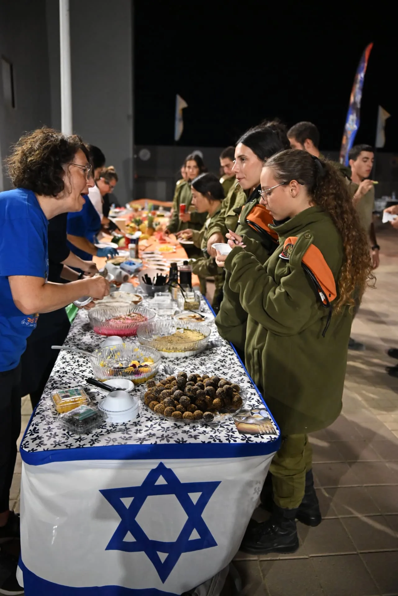 Soldiers at the buffet table decorated with an Israeli flag
