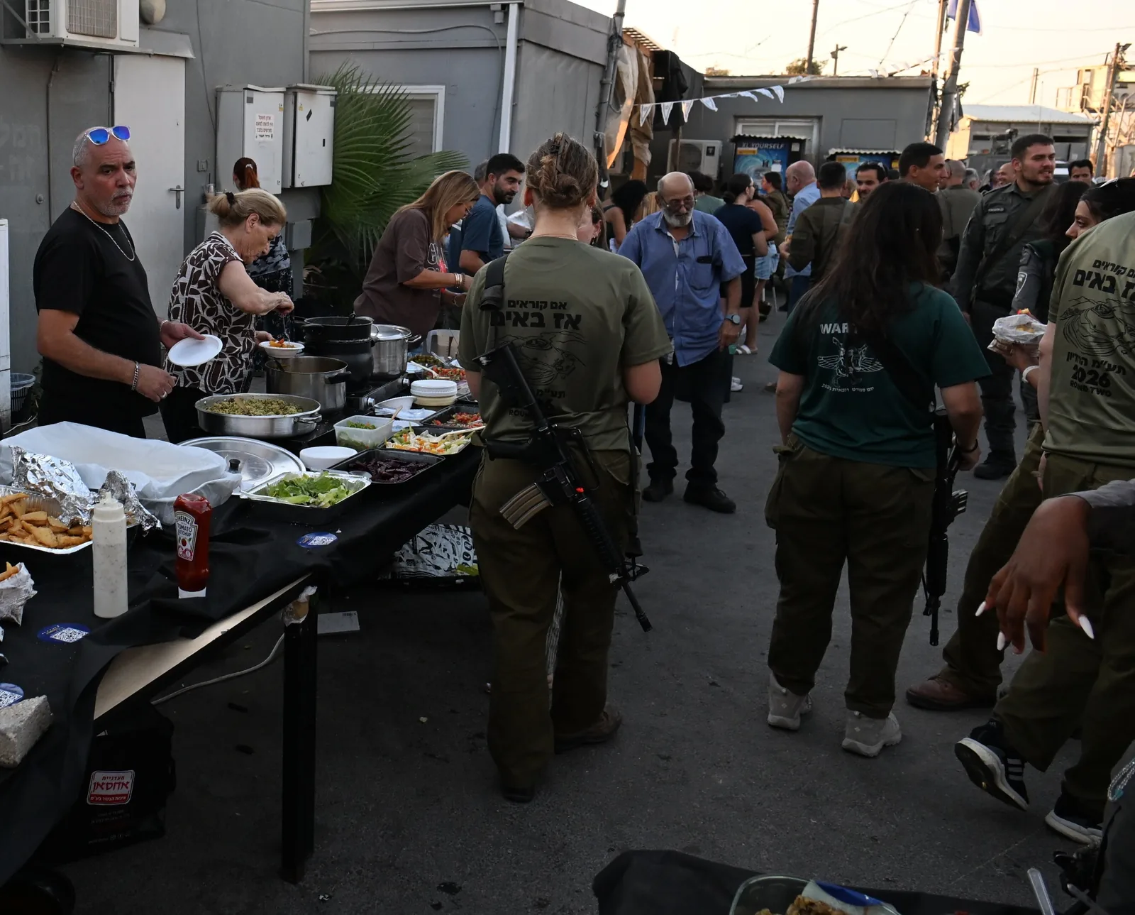 Volunteers serving home-cooked dishes from a long buffet line