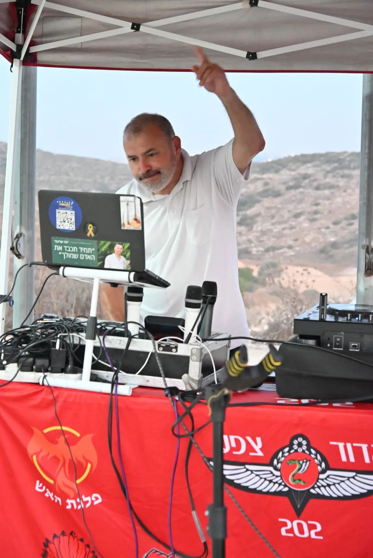 A DJ leading the music beside the battalion banner