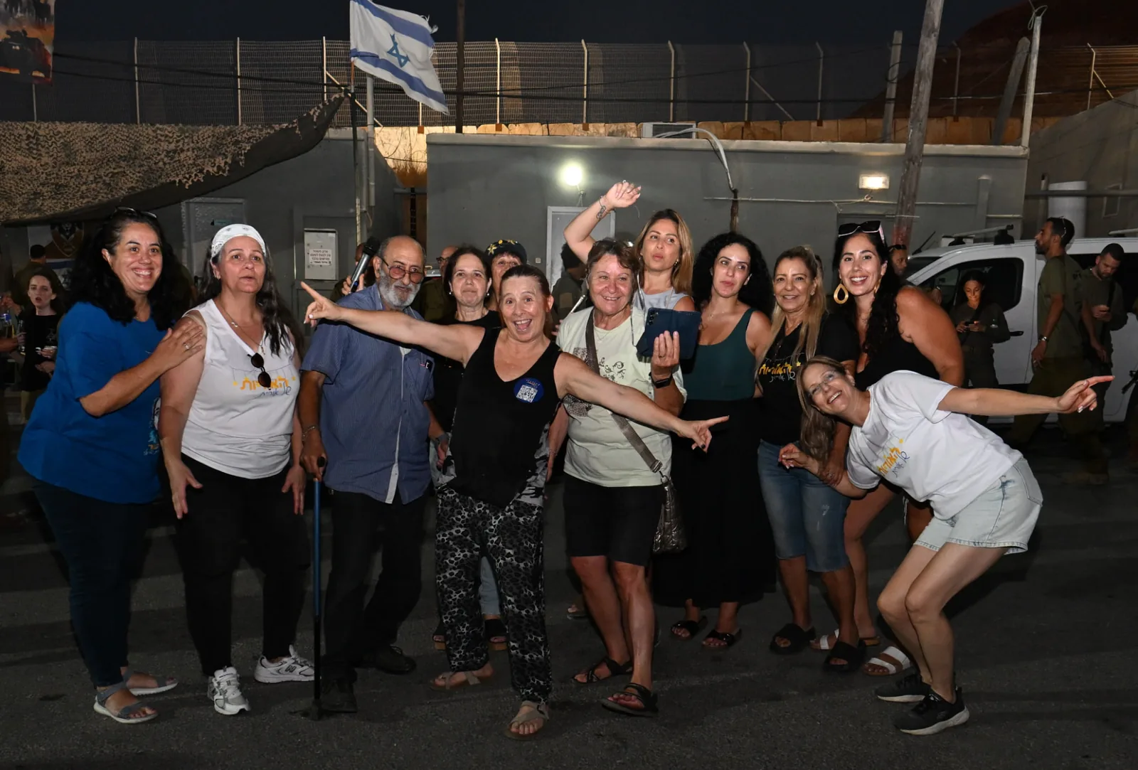 The volunteer team celebrating together under the Israeli flag at the end of the evening