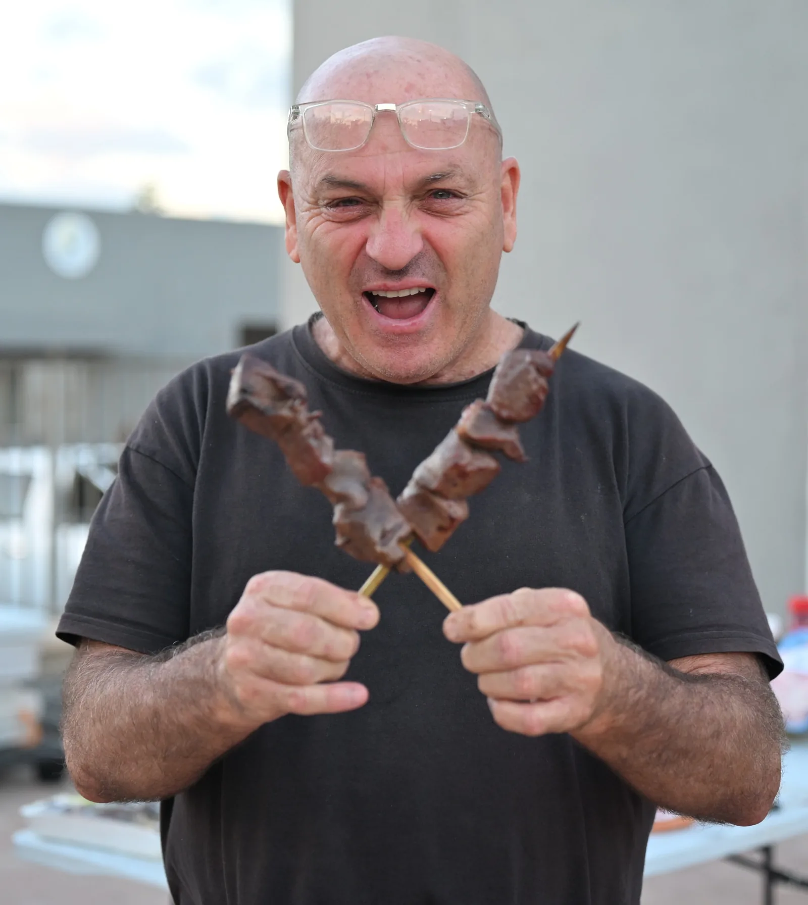A volunteer holding freshly grilled skewers