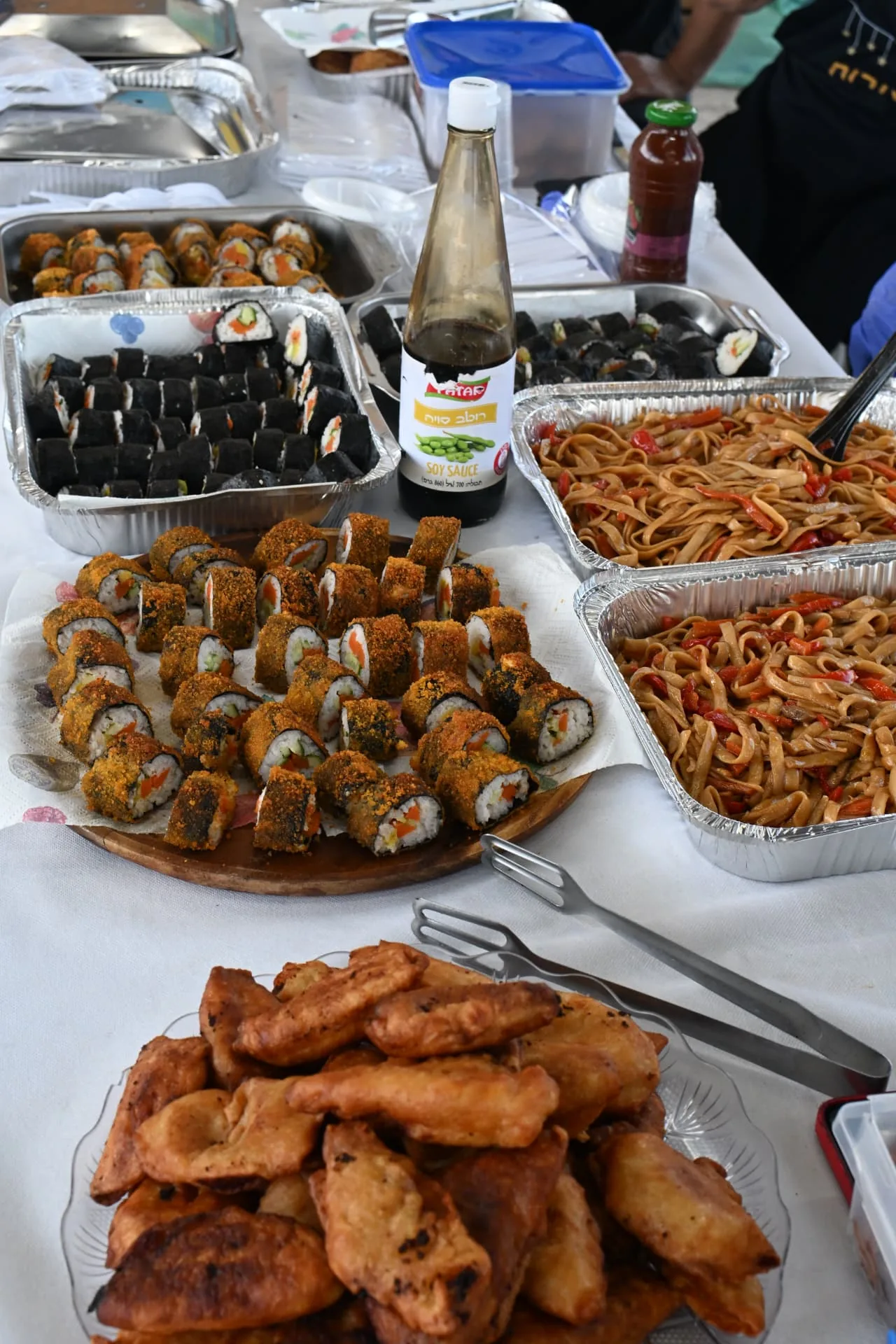 A buffet table laid with sushi rolls, stir-fried noodles and fresh pastries for the soldiers