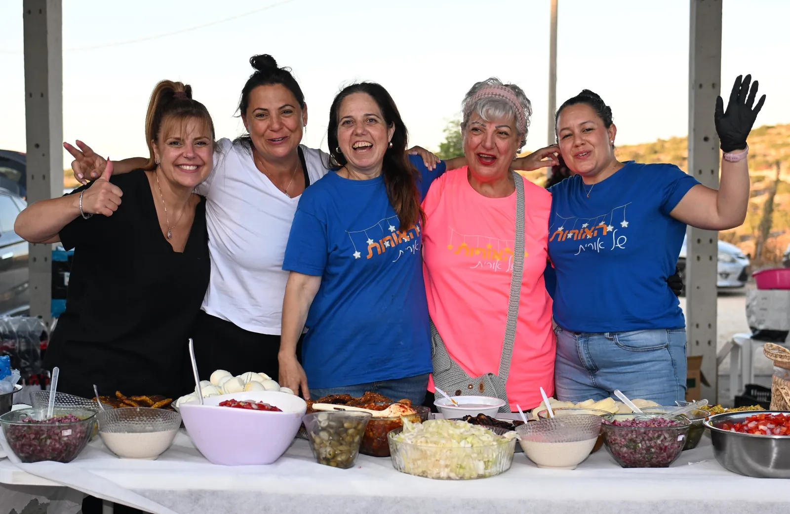 Volunteer team behind the table of home-cooked dishes