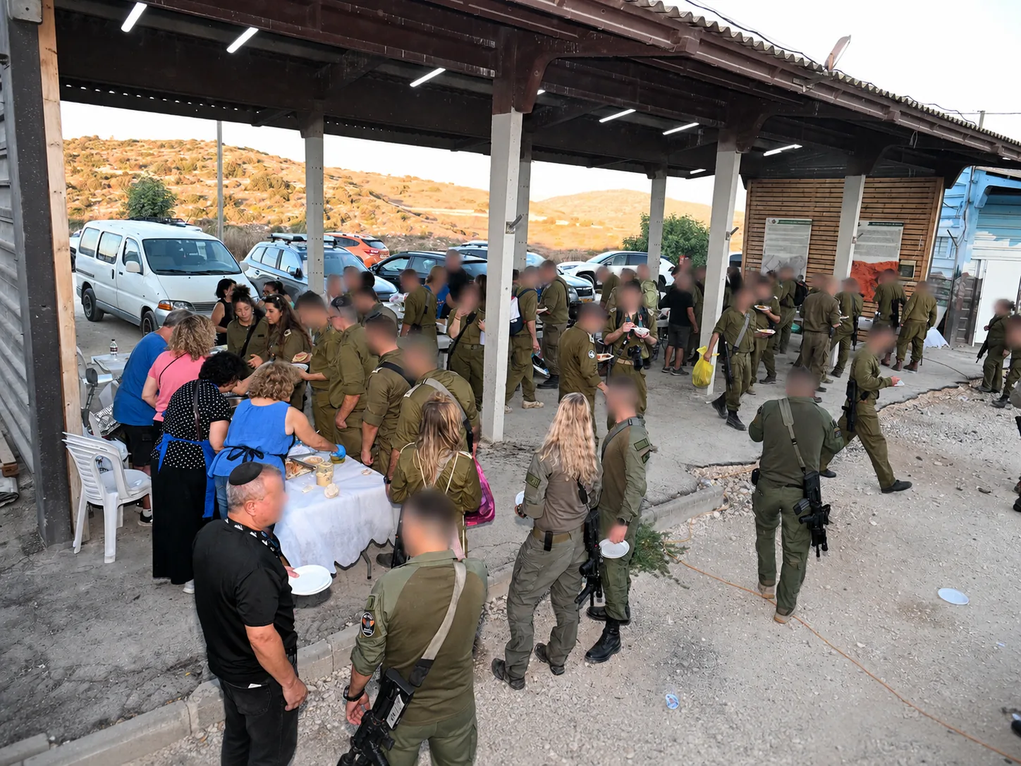 Wide view of the evening of appreciation with soldiers gathering at the hillside base