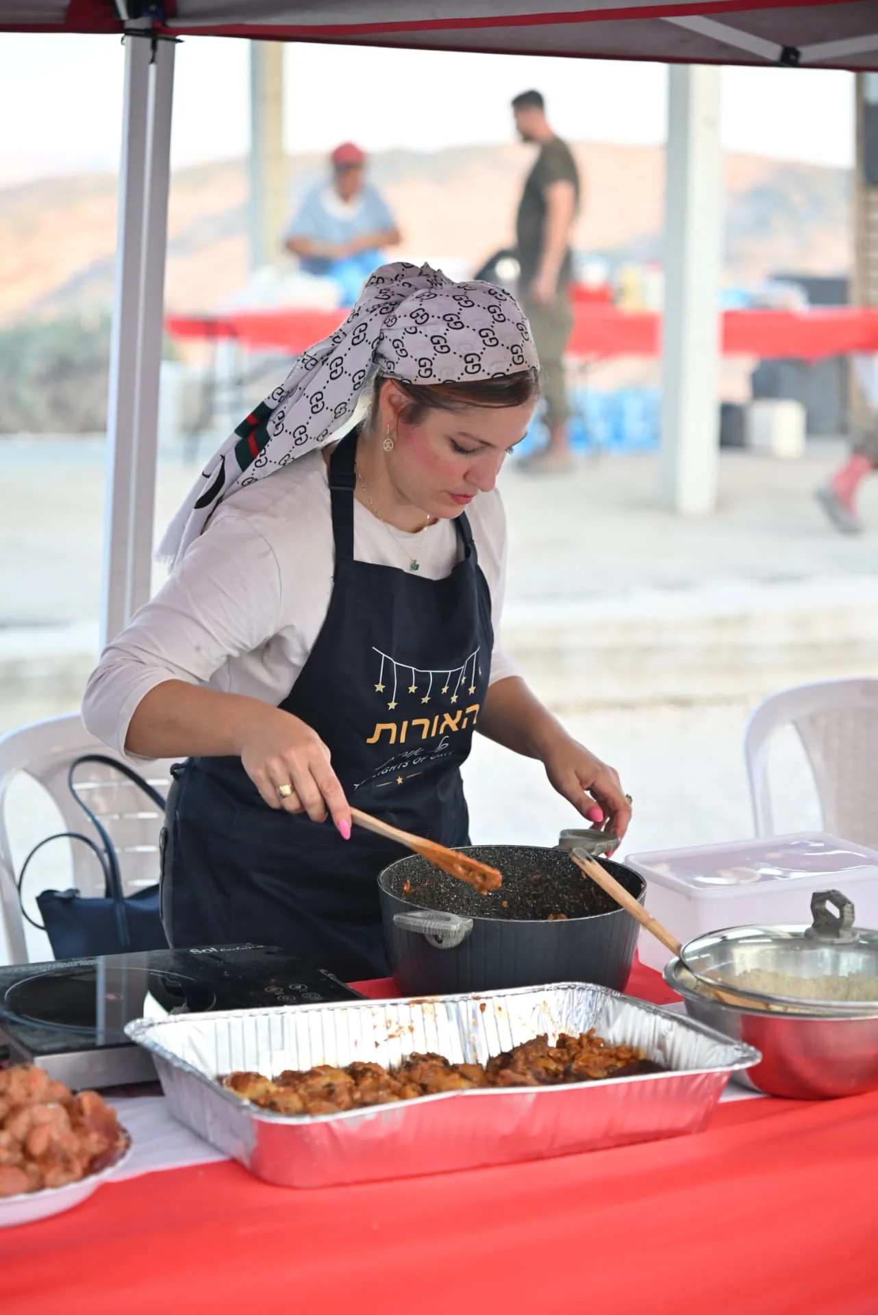 A volunteer stirring a pot of stew at the field kitchen
