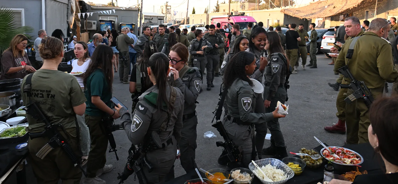 A crowd of soldiers sharing hot food and salads at the evening of appreciation