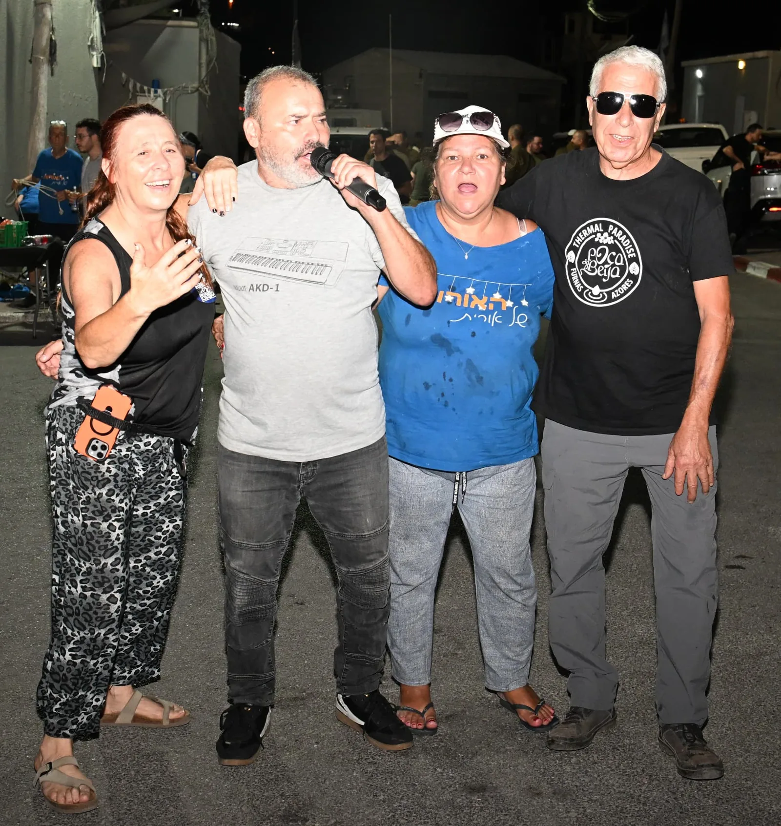 Volunteers singing together with a microphone during the evening